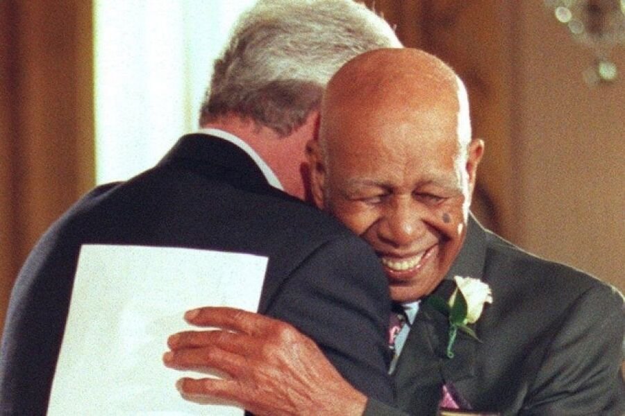 President Bill Clinton embraces Tuskegee survivor Herman Shaw.