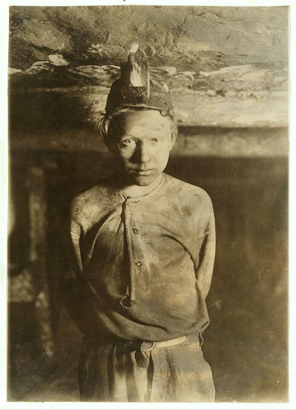 Sepia portrait of a young mine worker facing the camera.